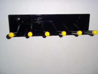 WOOD STORAGE RACK PAINTED IN BLACK WITH 6 WOOD DOWELS WITH YELLOW 