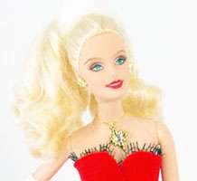Barbie is wearing a gold necklace with matching earrings. View larger 
